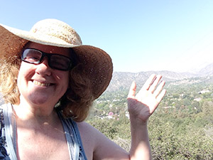 Laurie waves from the top of a trail at Descanso Gardens