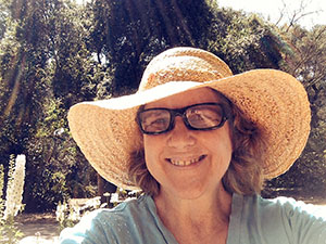 Laurie in front of the white flower bed at Descanso Gardens on a sunny day