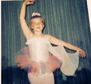 Laurie at age 7 wearing a rainbow colored tutu