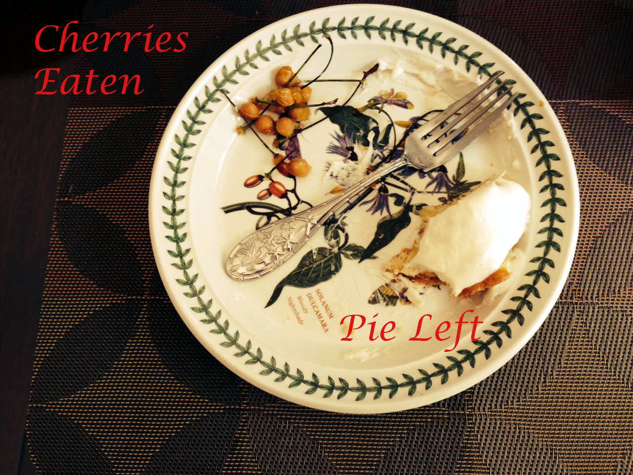 Plate with cherry pits and part of a pie slice