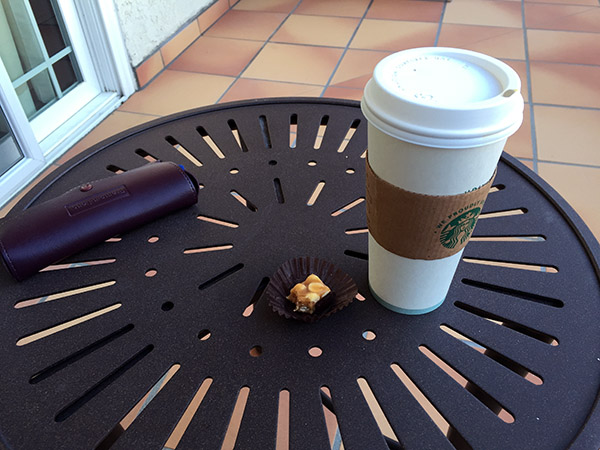 Coffee cup and half of a chocolate on a table
