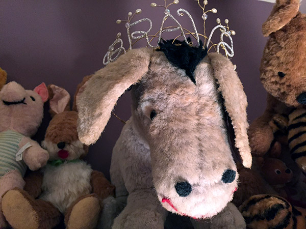 Stuffed Eeyore donkey toy wearing a tiara with the word BRAVE worked into it