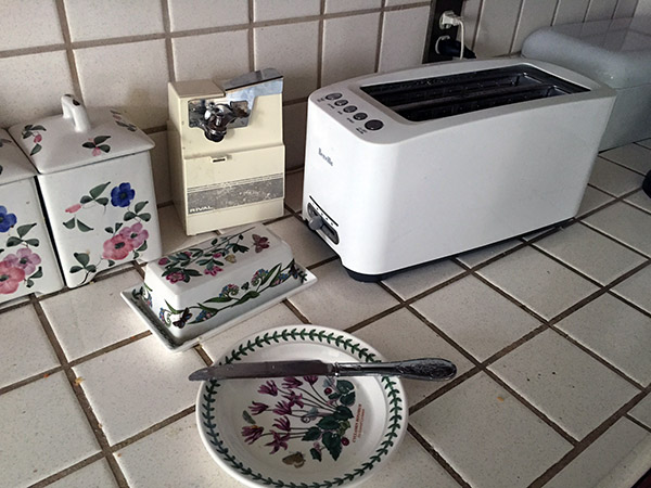 Toaster and botanical garden plates on a white tiled counter