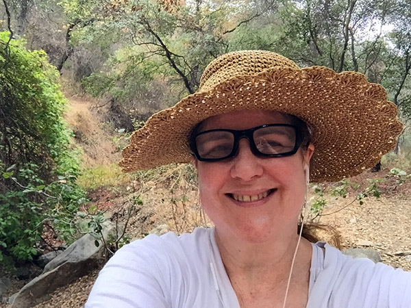 Laurie in straw hat in a woodland glade.