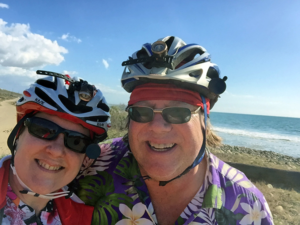 Laurie and Mark at the ocean wearing bike helmuts