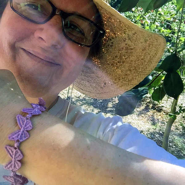 Laurie shows off a purple butterfly bracelet in the camellia forest
