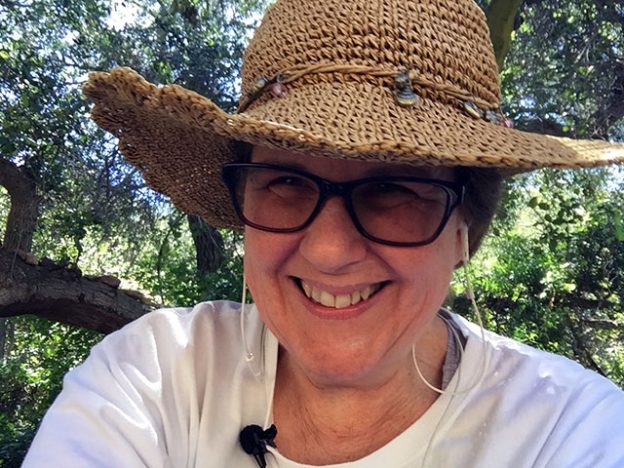 Laurie smiling broadly in a straw hat