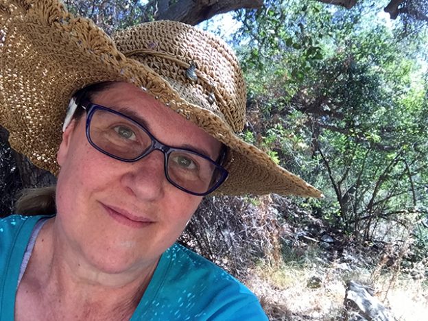 Laurie gives an emotional smile in close-up under the trees