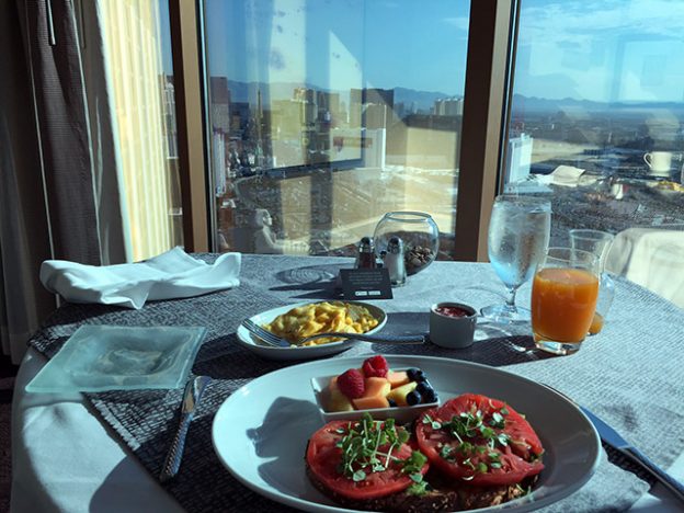 Close up of breakfast in front of floor to ceiling windows showing the Vegas Strip during the day
